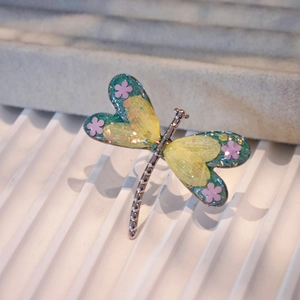 Macro shot of colorful resin wings with flower detail on dragonfly stainless steel ring