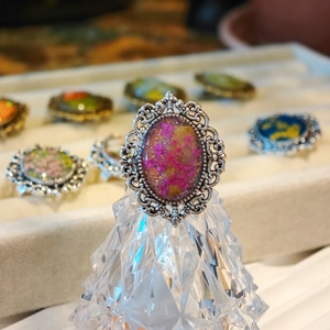 Close-up of vintage lace alloy ring featuring pink dried flowers in clear resin
