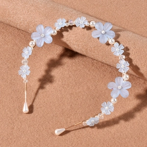 Detail eines Haarreifs im koreanischen Stil mit matten blauen Blumen, Perlen und Golddraht