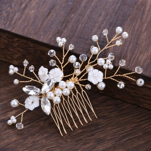 Exquisite bridal hair comb with pearls and crystals on a rustic dark wood surface