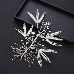 Handmade bridal hairpiece with white tubular beads and floral branches on a black background