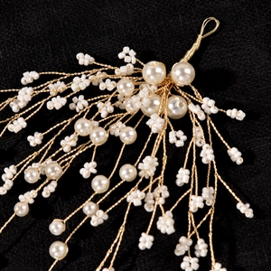 Handmade bridal hair clip with white pearls and gold wire branches for wedding hairstyles