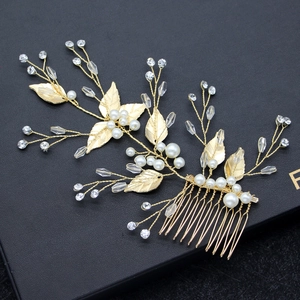 Detailed close-up of golden leaf hair comb with white pearls and sparkling rhinestones