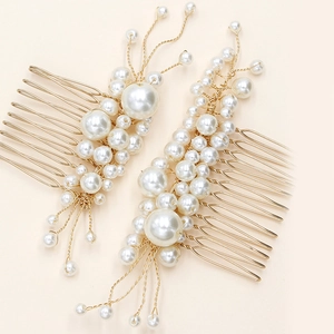 Detail of handcrafted gold wire bridal hair combs with white pearls in a leaf design