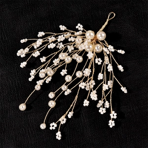 Elegant gold wire bridal hair clip with white pearls and beaded flowers on black leather