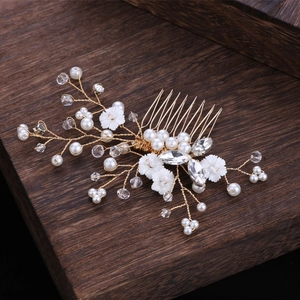 Exquisite bridal hair comb with pearls and crystal flowers on elegant wood background
