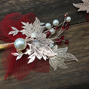 Detail of red pleated mesh bridal hair clips with golden leaves and white pearls
