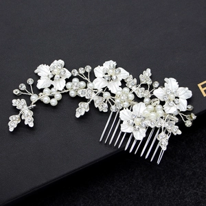 Silver flower hair comb with white pearls and sparkling rhinestones for bridal hairstyle