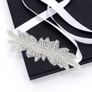 Luxury silver bridal headband with crystal leaves and white satin ribbon on a black box