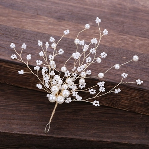 Elegant gold bridal hair pin with handcrafted pearls and beads on a rustic wooden base