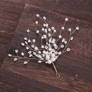 Detail of handcrafted gold wire hairpin with white pearls and flowers on wood