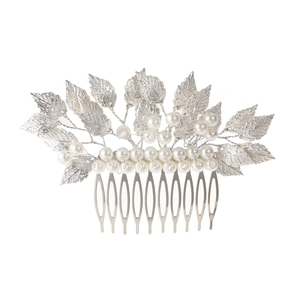 Macro shot of bridal silver leaf hair comb with elegant pearl accents for wedding styling