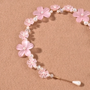 Detailaufnahme von rosa matten Blumen-Haarband mit weißen Perlen und klaren Kristallen