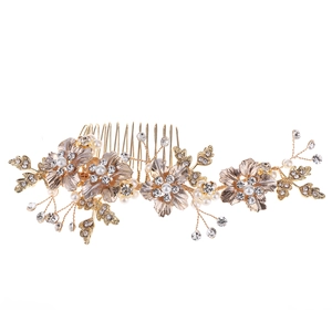 Detail of bridal hair comb with gold metal flowers, pearls, and sparkling rhinestones