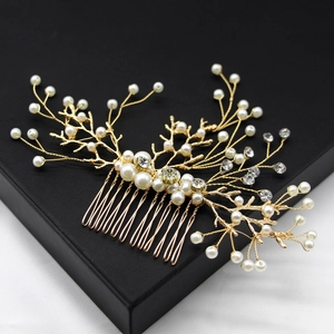 Macro view of handmade bridal hair comb with gold wire branches, pearls and rhinestones
