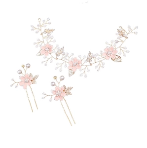 Macro detail of the golden bridal hair set with pink floral petals and white pearls