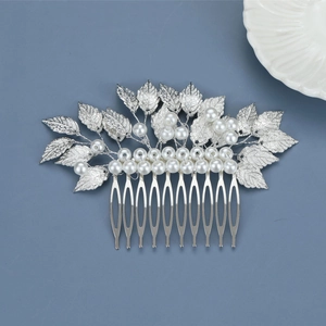 Macro detail of silver baroque leaf metal hair comb with white pearls for bridal styling