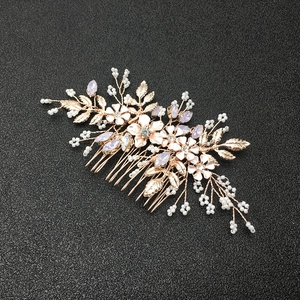 Dettaglio del pettine da sposa in oro rosa con fiori di smalto rosa e perle su sfondo nero