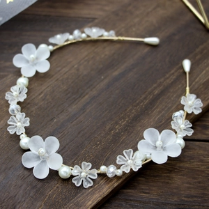 Detail eines floralen Haarreifs mit matten Blumen, Perlen und Kristallen auf Golddraht