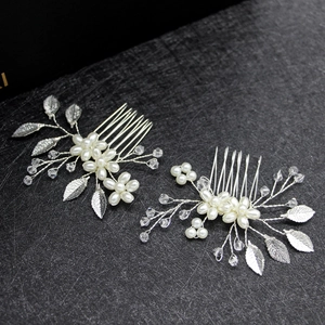 Close-up detail of silver alloy bridal hair combs with white pearls and frosted leaves