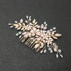 Dettaglio di pettine sposa oro rosa con petali rosa, perle e cristalli lucenti