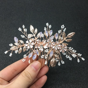 Dettaglio macro del pettine per capelli in oro rosa con fiori di smalto rosa e perle