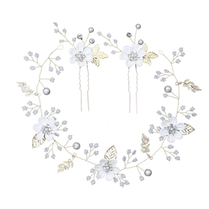 Detailed view of floral bridal hair vine with white flowers, gold leaves and pearls