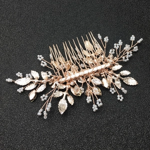 Dettaglio del pettine per capelli in oro rosa con perle bianche e strass brillanti