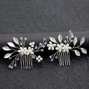Silver bridal hair comb set with pearls and alloy leaves on a dark textured display