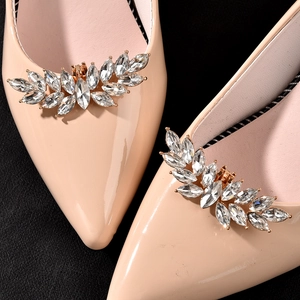 Elegant pointed-toe pumps in nude patent leather with marquise rhinestone leaf buckle