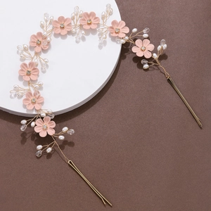 Nahaufnahme von rosa Stoffblumen mit Perlen und Kristallen auf goldenem Braut-Haarband