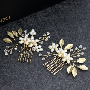 Detailed view of handmade gold bridal hair combs with pearls and alloy leaves