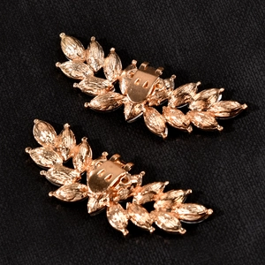 Detail view of rose gold laurel leaf shoe clips with metallic brushed texture finish
