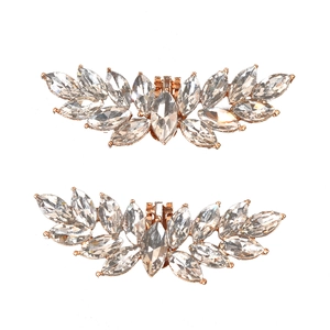 Detailed macro view of rose gold shoe clips with marquise-cut crystal embellishments