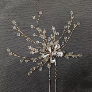 Gros plan d'épingle à cheveux de mariée dorée avec cristaux et détails de branche