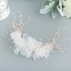 Coiffure de mariée avec fleurs en mousseline blanche et perles sur fil de fer champagne