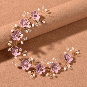 Details des Braut-Haarbands mit lila Stoffblumen und Perlen auf goldenem Draht