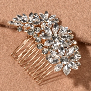 Macro detail of bridal hair comb with gold metal frame and clear marquise crystals