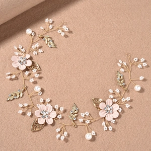 Détail d'une vigne de cheveux de mariée avec fleurs roses et perles faites main