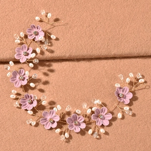 Detailansicht des handgefertigten Brauthaarschmucks mit rosa Blumen und Perlenakzenten