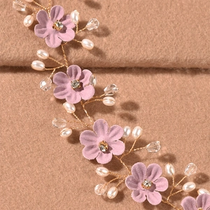 Detail eines Braut-Haarbands mit rosa Stoffblumen, Perlen und kleinen Kristallperlen