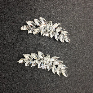 Detailed close-up of leaf-shaped alloy shoe clips with marquise-cut rhinestones