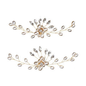 Dettaglio di accessori per capelli da sposa con perle e strass su filo dorato