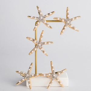 Five-piece golden starfish hair clips set with pearls and rhinestones on display