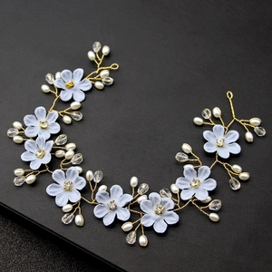 Detailansicht handgefertigter blauer Stoffblumen mit Strasssteinen und Golddraht-Haarband