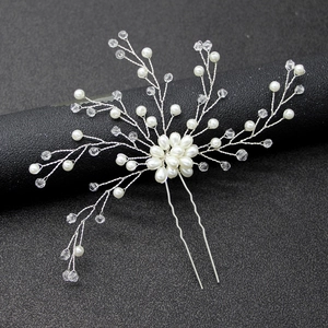 Dettaglio macro della forcina da sposa fatta a mano con perle e cristalli su filo d'argento