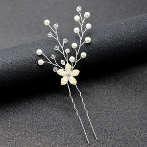Gros plan sur épingle à cheveux de mariée avec perles blanches et cristaux floraux
