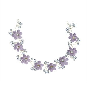 Detailansicht des handgefertigten Brauthaarbands mit lila Stoffblumen und Kristallen