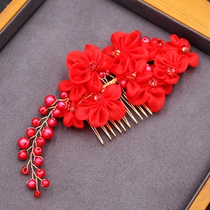 Detail of red satin flower hair comb with rhinestones and pearl tassels for weddings