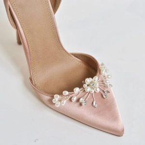 Dettaglio di scarpe da sposa in raso rosa con fiore di perle e strass fatto a mano